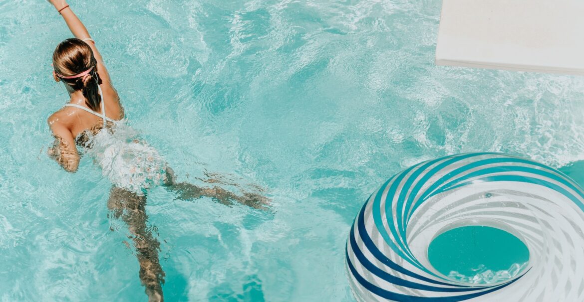 girl wearing swimsuit and swims in swimming pool