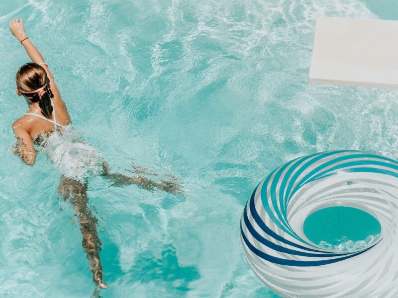 girl wearing swimsuit and swims in swimming pool