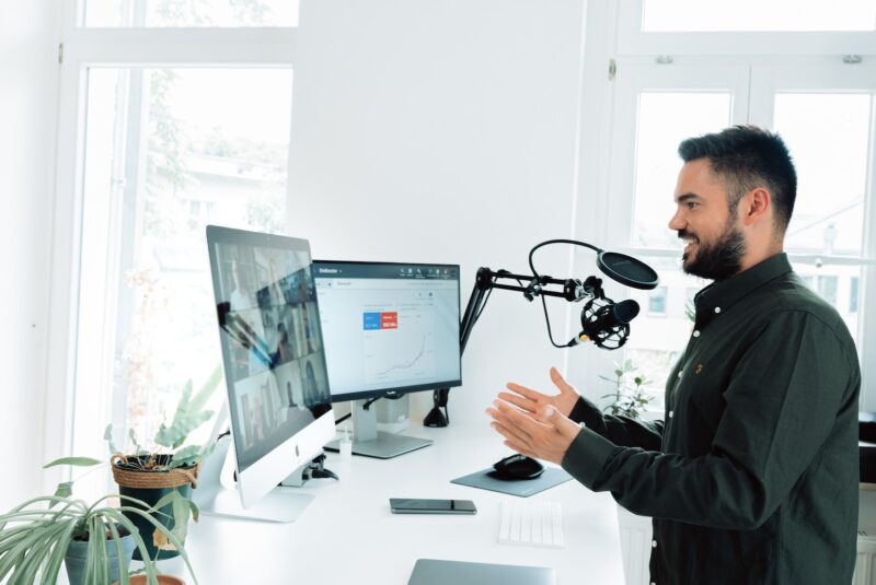 man in black jacket holding black corded computer mouse