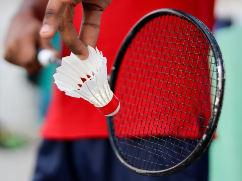 person holding red and black tennis racket