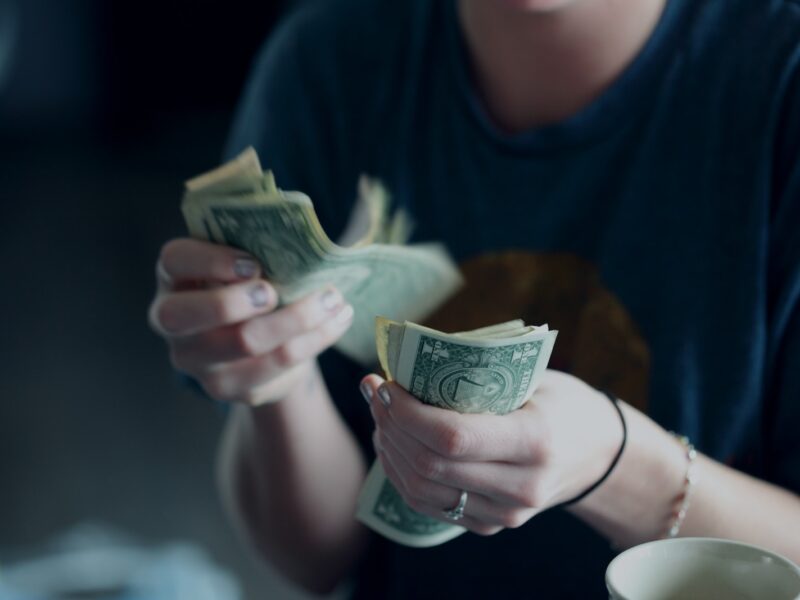 focus photography of person counting dollar banknotes