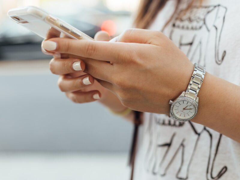 woman holding iPhone during daytime