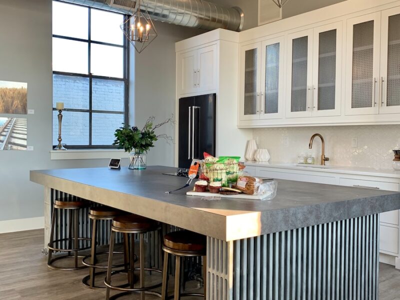 gray metal island table near white wooden kitchen cabinet