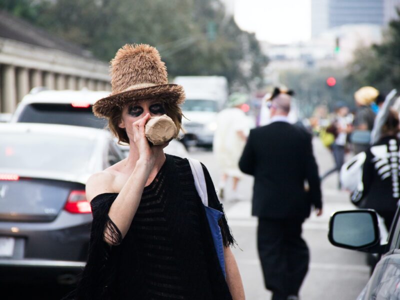 woman drinking from bottle while standing near traffic