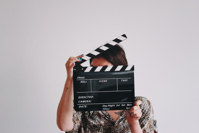 a woman holding a clapper over her face