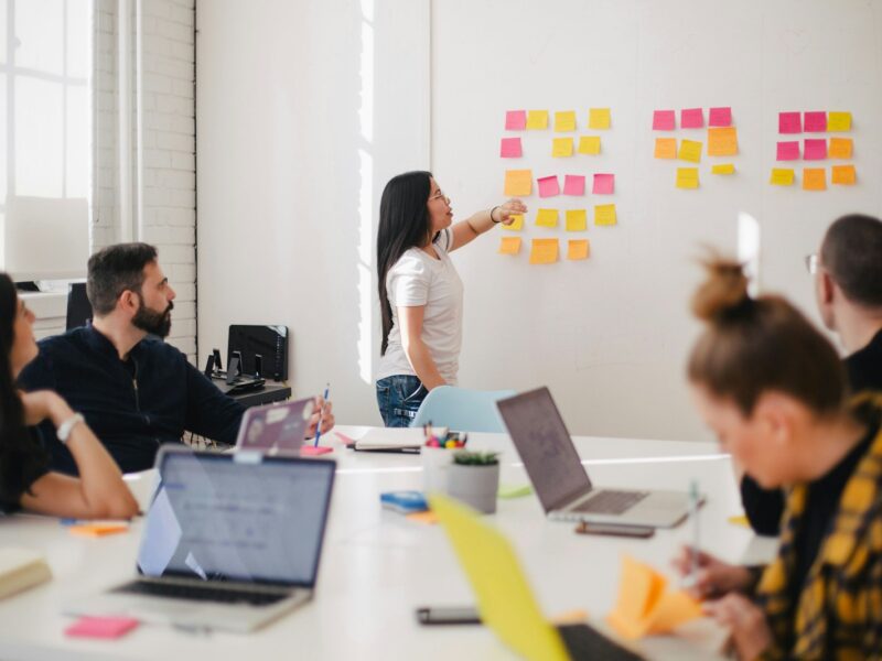 woman placing sticky notes on wall